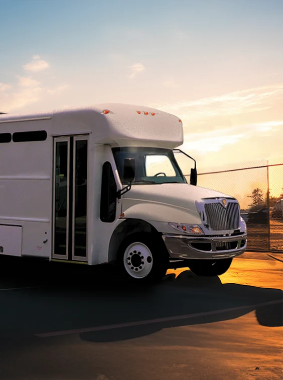 White shuttle bus parked next to a security fence at a prison near Portland